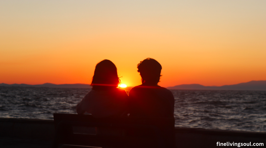 couples sitting by the beach on a sunset reflecting on their relationship